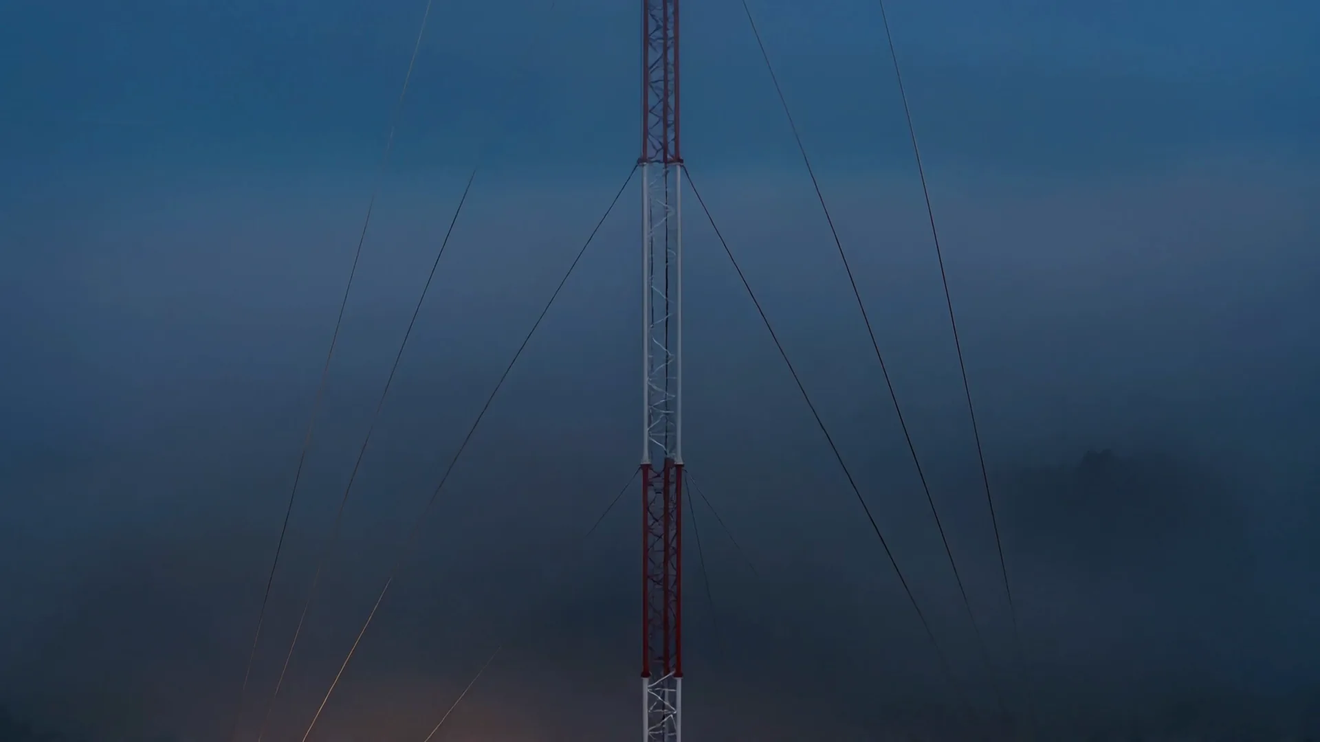 The lower guy collar on the mast, three tensioned wires fanning down to their ground anchors